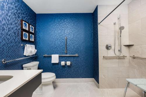 a bathroom with a toilet and a shower with blue tiles at Hotel Westport Kansas City, Tapestry Collection by Hilton in Kansas City