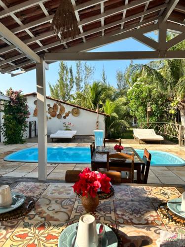 a patio with a table and a swimming pool at Pousada da Renata in Jericoacoara