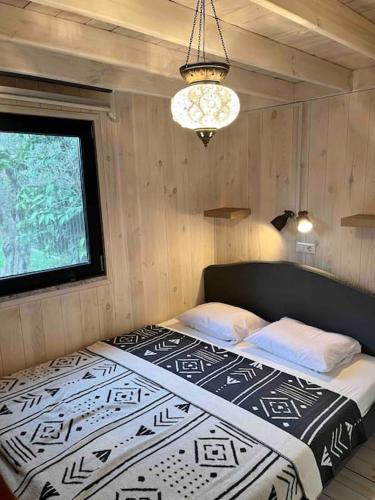 una camera con un letto in una stanza con una finestra di Beyaz Zambak'ta doğayı yaşayın a İznik
