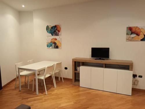 una sala da pranzo con un tavolo bianco e una televisione di La casa di Elenù a Posillipo a Napoli