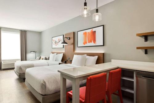 a hotel room with two beds and a table and chairs at Hawthorn Extended Stay by Wyndham Mount Laurel Moorestown in Mount Laurel