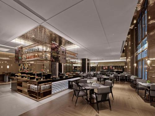 a restaurant with tables and chairs and a bar at DoubleTree By Hilton Cangnan in Cangnan
