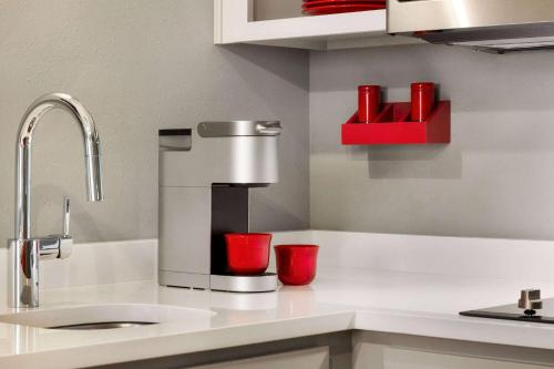 a kitchen counter with a coffee maker and red cups at Hawthorn Extended Stay by Wyndham Mount Laurel Moorestown in Mount Laurel