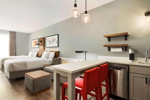 a hotel room with a bed and a kitchen with a table at Hawthorn Extended Stay by Wyndham Mount Laurel Moorestown in Mount Laurel