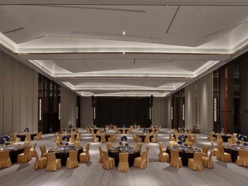 a banquet hall with tables and chairs and a stage at DoubleTree By Hilton Cangnan in Cangnan