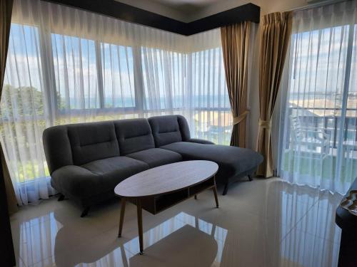 a living room with a couch and a table at LHC HOTEL AND RESORT in Pattaya Central