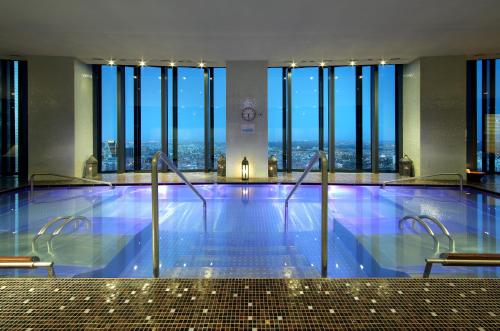 a large swimming pool in a building with windows at Eurostars Madrid Tower in Madrid