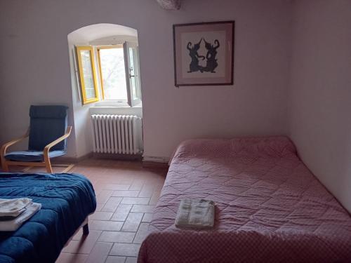 a bedroom with a bed and a chair and a window at Agriturismo CasaMatta Azienda Agricola in Calenzano
