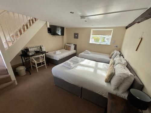 a room with two beds and a staircase at Rylands Farm Guest House in Wilmslow