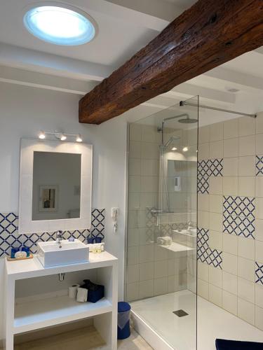 W łazience znajduje się prysznic, umywalka i lustro. w obiekcie Brin de Cocagne w mieście Fénols