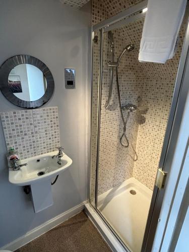 a bathroom with a shower and a sink at Rylands Farm Guest House in Wilmslow