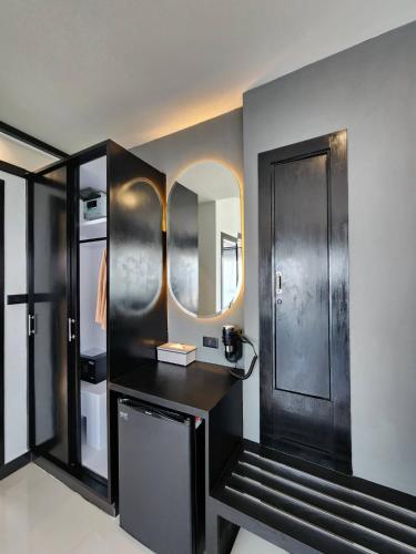 a dressing room with a mirror and a black door at LHC HOTEL AND RESORT in Pattaya Central