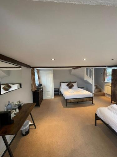 a large bedroom with two beds and a desk at Rylands Farm Guest House in Wilmslow