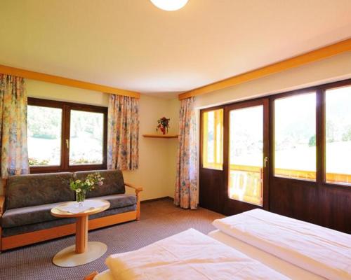 une chambre d'hôtel avec un lit, un canapé et des fenêtres dans l'établissement Haus Rätikon, à Brand