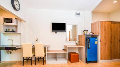 a kitchen with a table and a blue refrigerator at Journey Residence Phuket in Bang Tao Beach