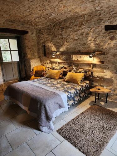 une chambre avec un lit dans un mur de pierre dans l'établissement Gite de charme 80 m², piscine, proche d'Uzès., à Vézénobres