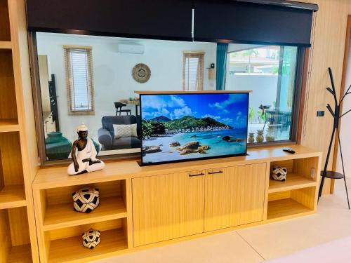 a living room with a flat screen tv on a wooden entertainment center at Yuka residence in Koh Samui 