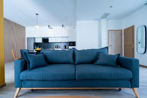 - un canapé bleu dans un salon avec une cuisine dans l'établissement Sublime Loft de 62 m2 secteur Castellane - L'élégant -, à Marseille
