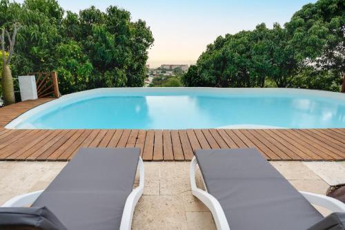 een groot zwembad met 2 ligstoelen ernaast bij Villa Oasis in La Possession
