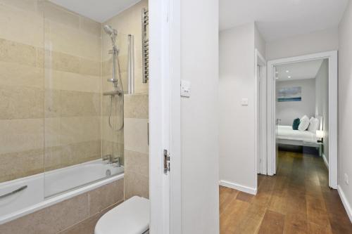 a bathroom with a tub and a toilet and a sink at Spacious 1 bedroom flat in London