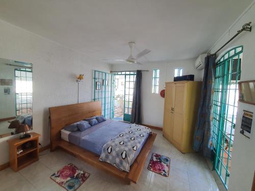 a bedroom with a bed and some windows at Appartement & Studio Lolla in Pereybere