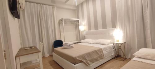 een witte slaapkamer met een bed en een spiegel bij Portonaccio suite - Stazione Tiburtina - Università - Metro B in Rome