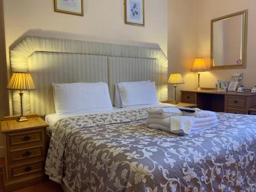 a bedroom with a large bed with white sheets and pillows at The Redcliffe Hotel in Scarborough