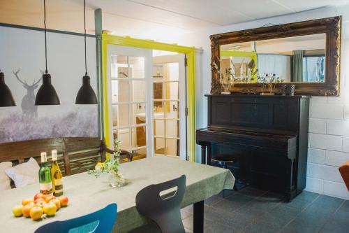 une salle à manger avec une table et un piano dans l'établissement Grijzegraaf vakantiewoning Voerstreek, à Fourons