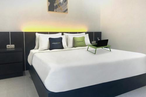 ein Schlafzimmer mit einem großen Bett und einem Laptop darauf in der Unterkunft Urbanview Hotel AnD Lampung by RedDoorz in Lampung