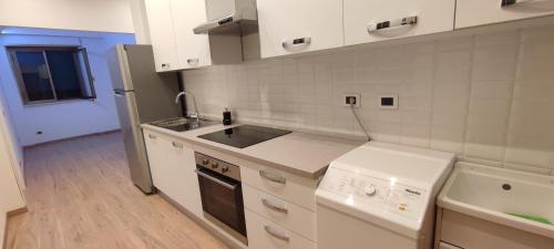 a white kitchen with a sink and a stove at Portonaccio suite - Stazione Tiburtina - Università - Metro B in Rome