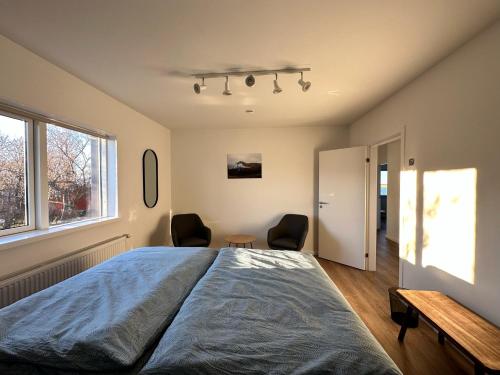 a bedroom with a large bed and two chairs at Apartment Fernsicht in Borgarnes