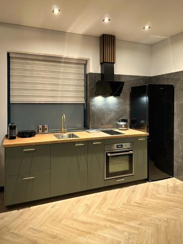 a kitchen with a sink and a stove at Luxe appartement dichtbij centrum C in Drachten