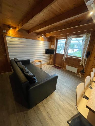 a living room with a black leather couch in a room at Langenuen Motel & Camping in Stord