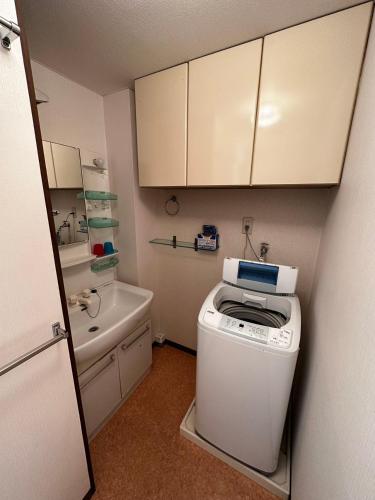 a laundry room with a washer and a sink and a counter at kaneshiro guest house in Tokyo