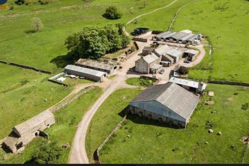an aerial view of a farm with buildings and a dirt road at Rural 5* Rookby Cottage, with large Hot Tub in Winton