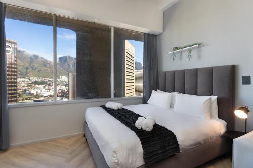 a bedroom with a large bed with a large window at One Thibault 2003 in Cape Town