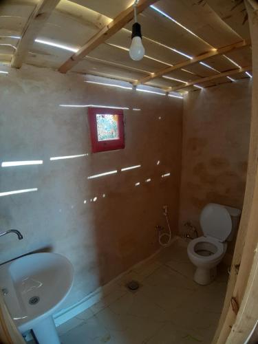 a bathroom with a toilet and a sink and a window at M Biama Island in Siwa