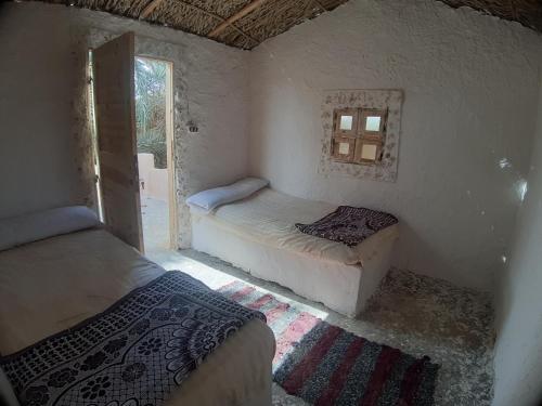 two beds in a room with a window at M Biama Island in Siwa