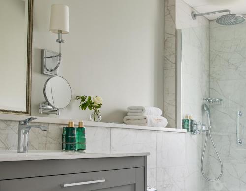 y baño con ducha y lavabo con espejo. en The Lodges at Glenlo Abbey Hotel and Estate, en Galway