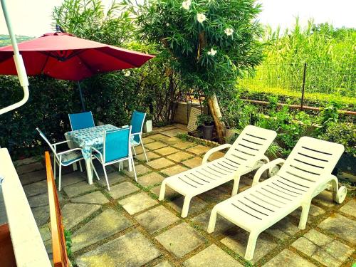 a patio with a table and chairs and an umbrella at Giardino delle Fate in Villa Rosa