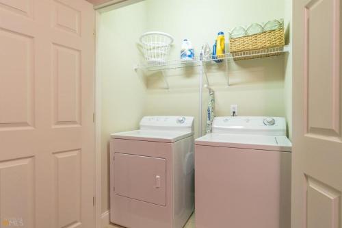 a white laundry room with a washer and a sink at Riverfront home within walking distance of Helen in Helen