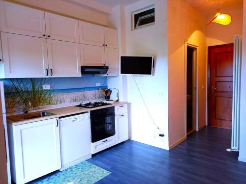 a kitchen with white cabinets and a black appliance at Giardino delle Fate in Villa Rosa