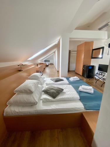 a large bed with white sheets and pillows in a room at Boutique Hotel & Event Center in Budapest
