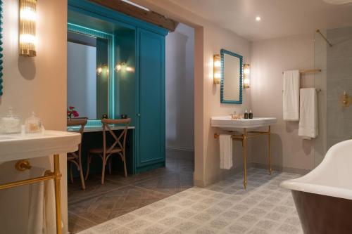 een badkamer met een blauwe deur en een wastafel bij Blacksmith's Cottage in Nantwich