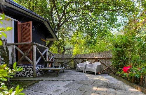 eine Terrasse mit Stühlen, einem Tisch und einem Zaun in der Unterkunft Village Camping Santa Fortunata - Campogaio in Sorrent