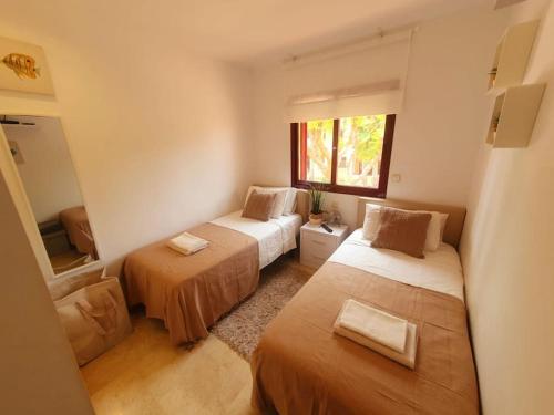 - une chambre avec 2 lits et une fenêtre dans l'établissement Pure Beach Penthouse & Swimming pool, 3 bedrooms, à Los Alcázares