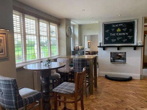 a dining room with tables and chairs and a tv at The Crown of Cookham in Cookham