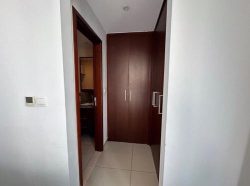 a hallway leading to a bathroom with wooden cabinets at Downtown Apartments with Fountain and Burj Khalifa View in Dubai