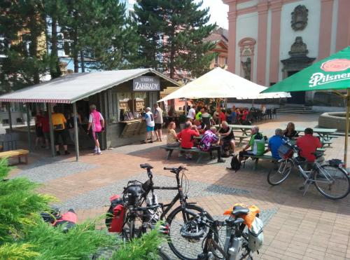 a group of people sitting at a market with bikes at Apartments Rose Garden in Děčín