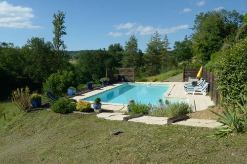 une piscine dans une cour avec des chaises autour dans l'établissement Guest House Château le But proche de Périgueux en Dordogne, à Léguillac-de-Lauche